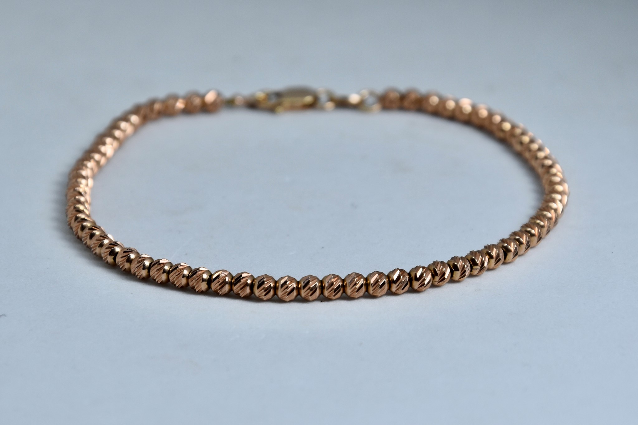 Immagine di BRACCIALE PALLINE SFACETTATE ORO ROSSO